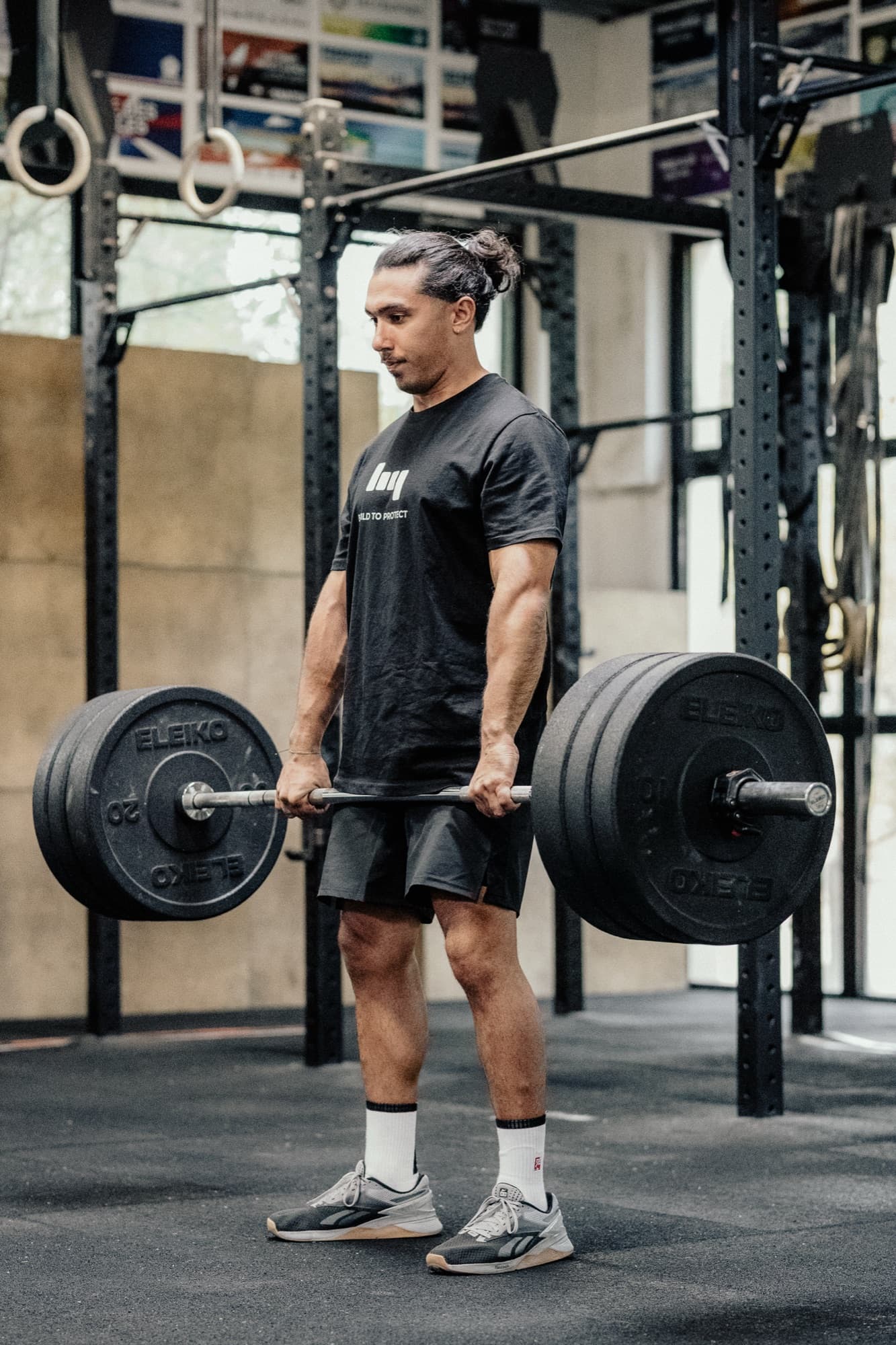 Atleta preparando um Hang squat clean com barra olímpica.