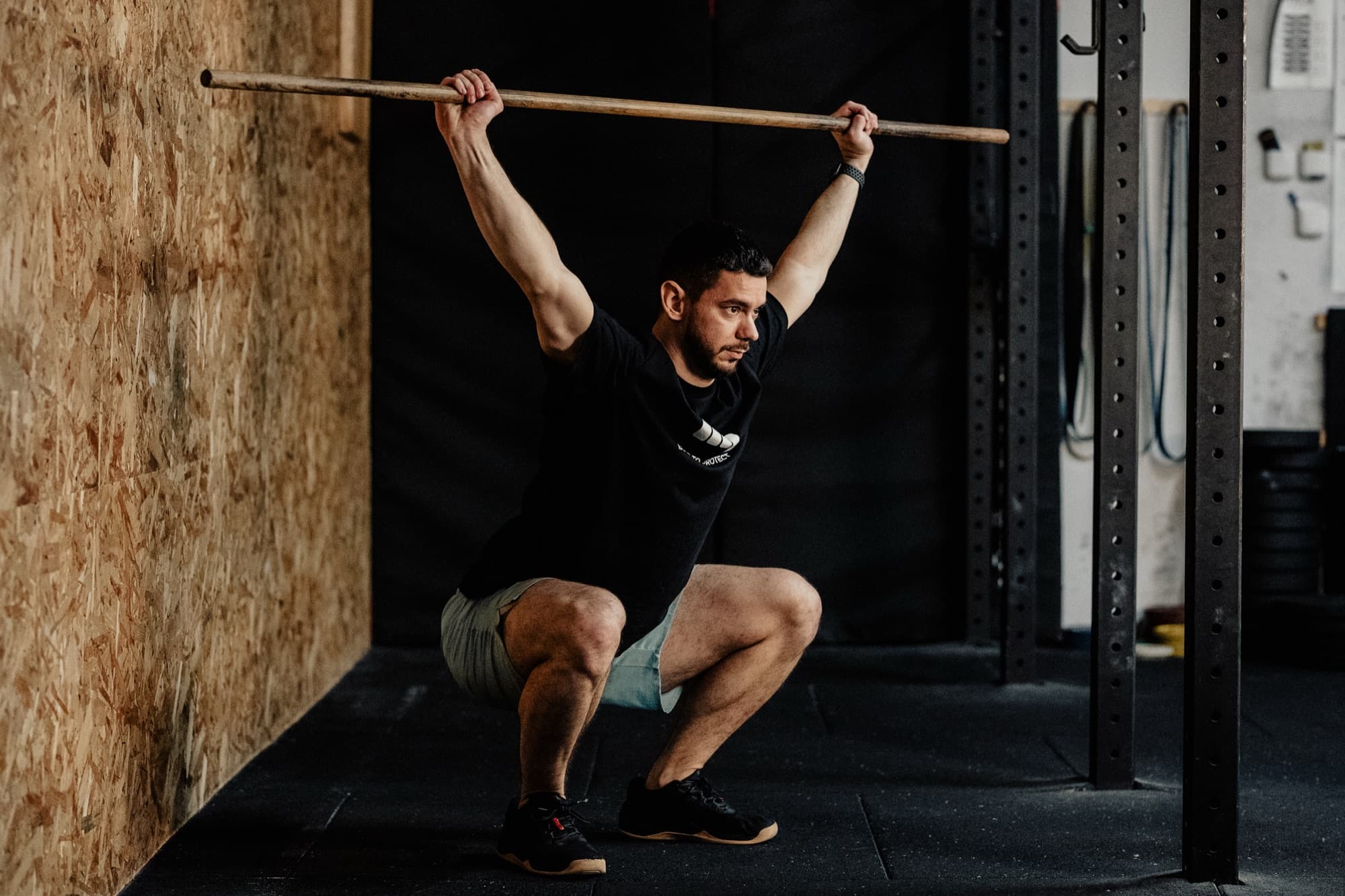 Athlète réalisant un overhead squat avec bâton lors du test de mouvement